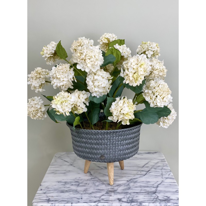 Ein hochwertiges künstliches Hortensien-Arrangement in einem Rattantopf