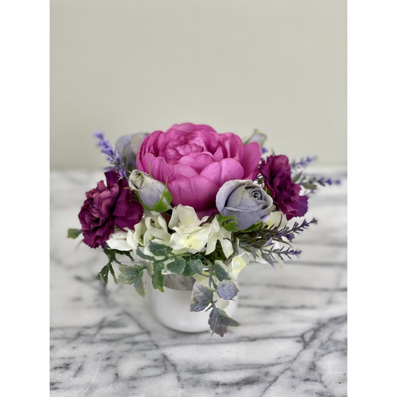 Kleines Kunstblumenarrangement in einer Vase befestigt