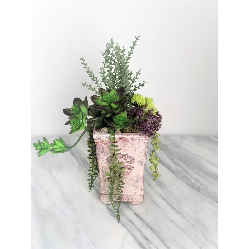 Künstliche Sukkulenten in einer Vase aus Beton